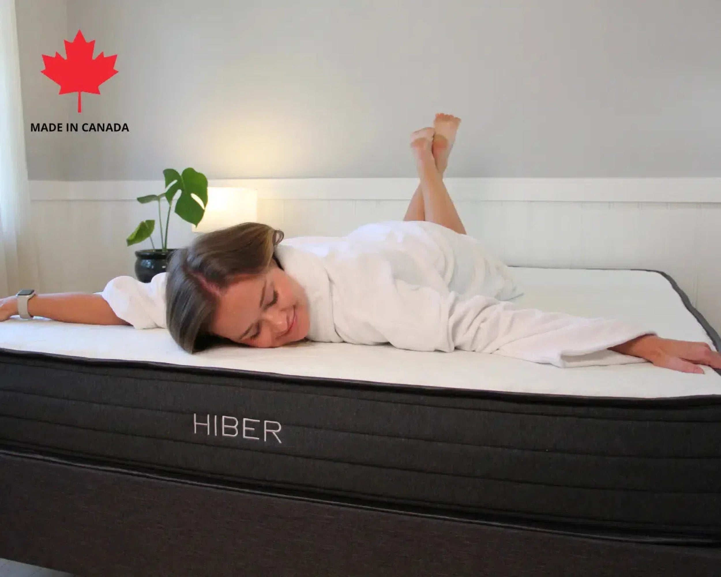 Side view of HIBER8 8-inch mattress with woman in white robe resting comfortably, showcasing Canadian-made comfort.