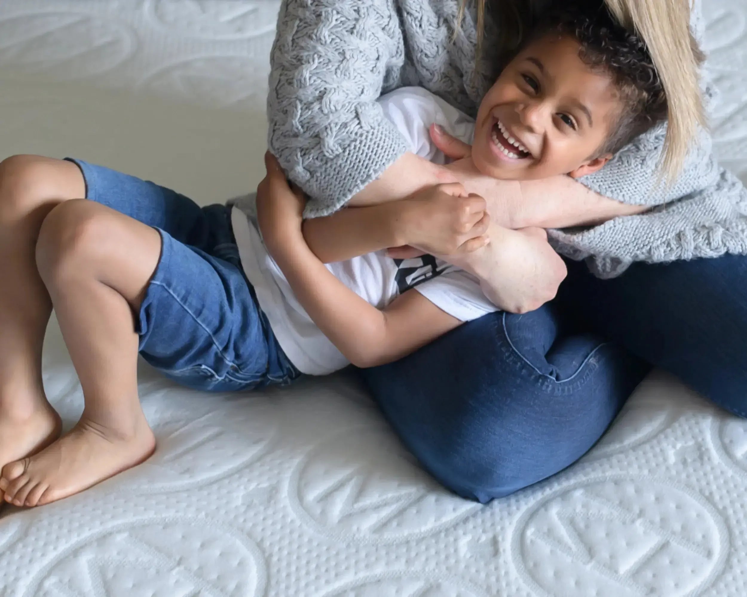 Mother hugging child while sitting on Haven Mattress.