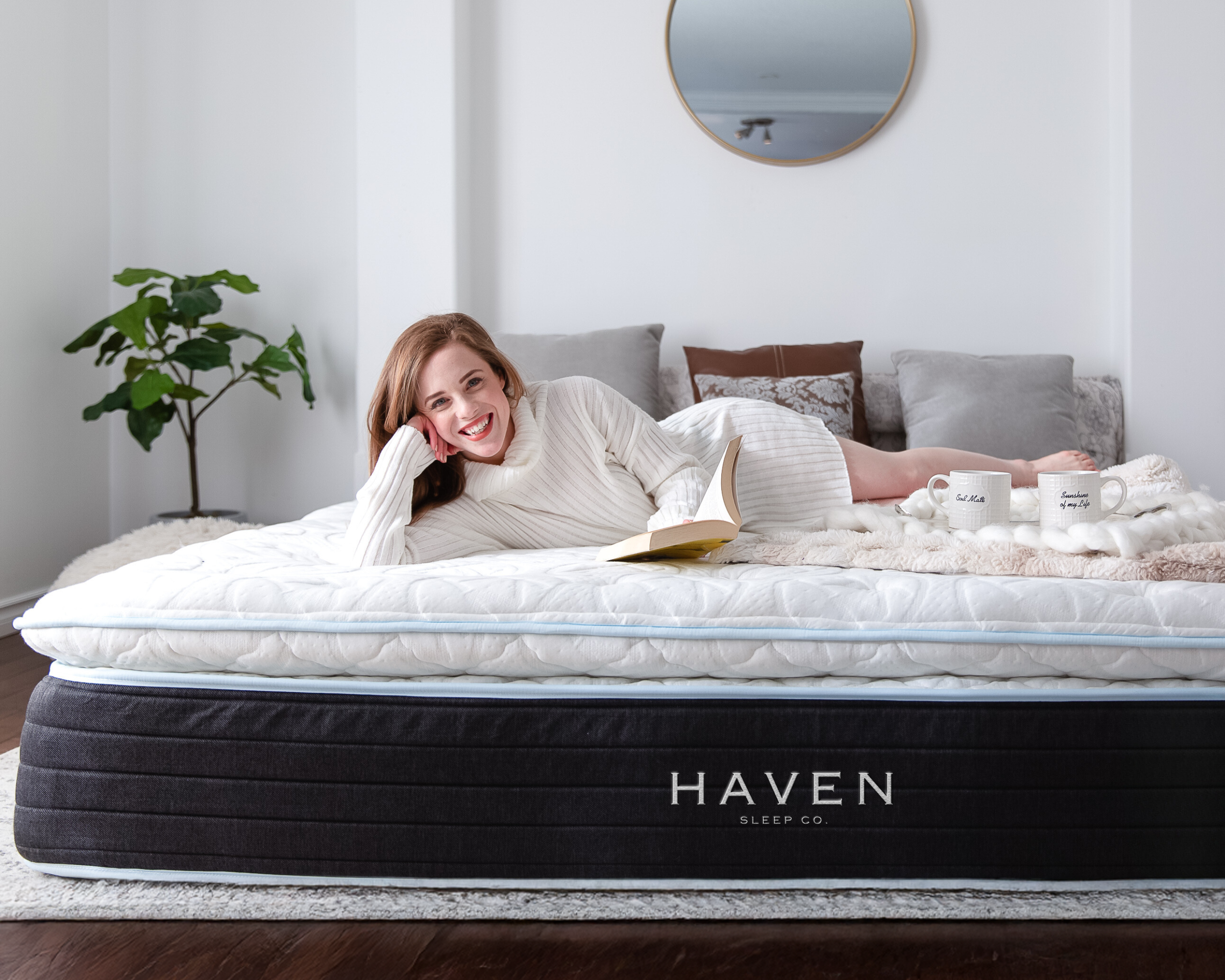 Woman relaxing with a book on a Haven LUX Pillowtop Hybrid Mattress, Canadian-made luxury bed with plush top in cozy, modern bedroom