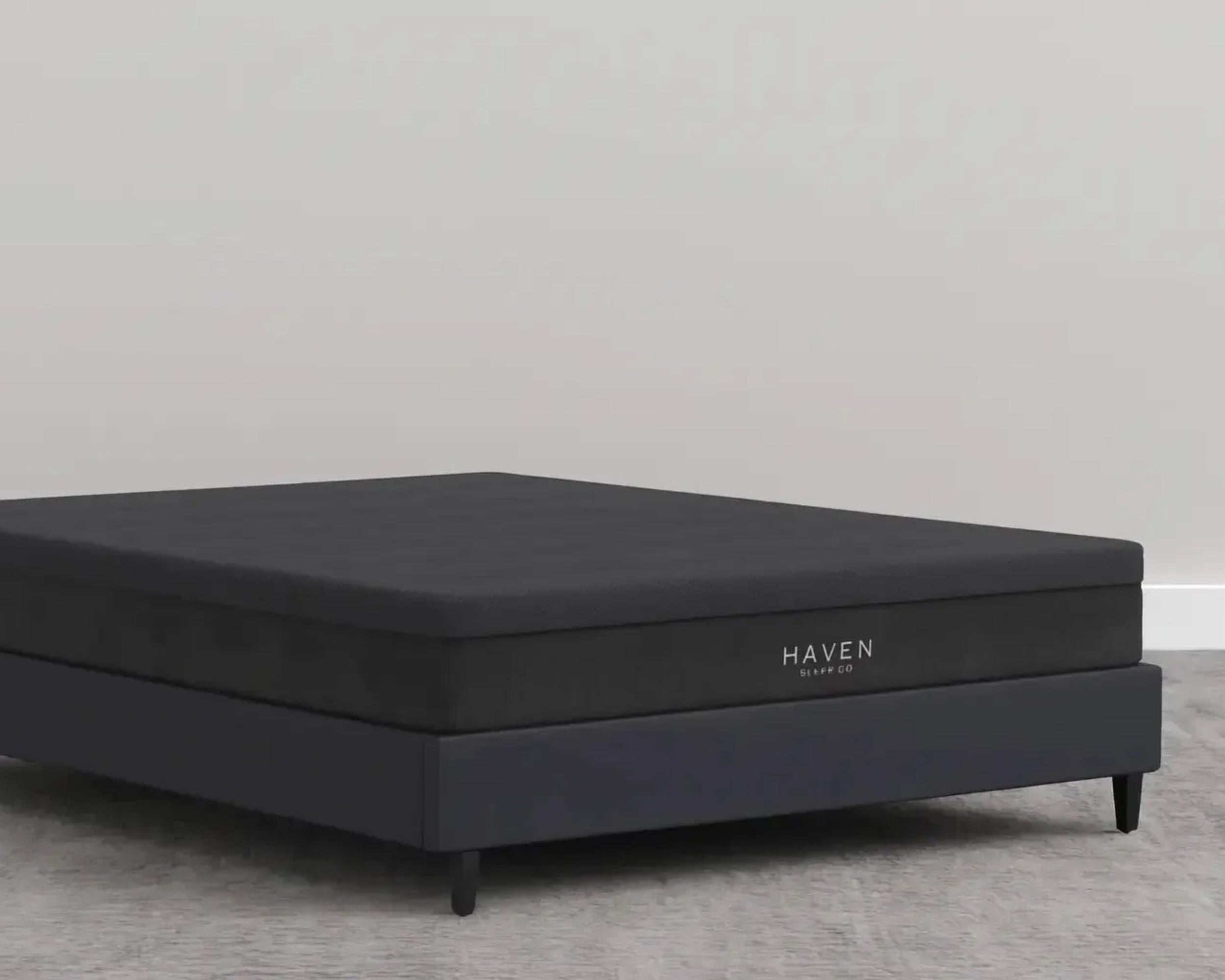 Black Haven mattress on a gray floor with a red maple leaf logo and 'Made in Canada' text.