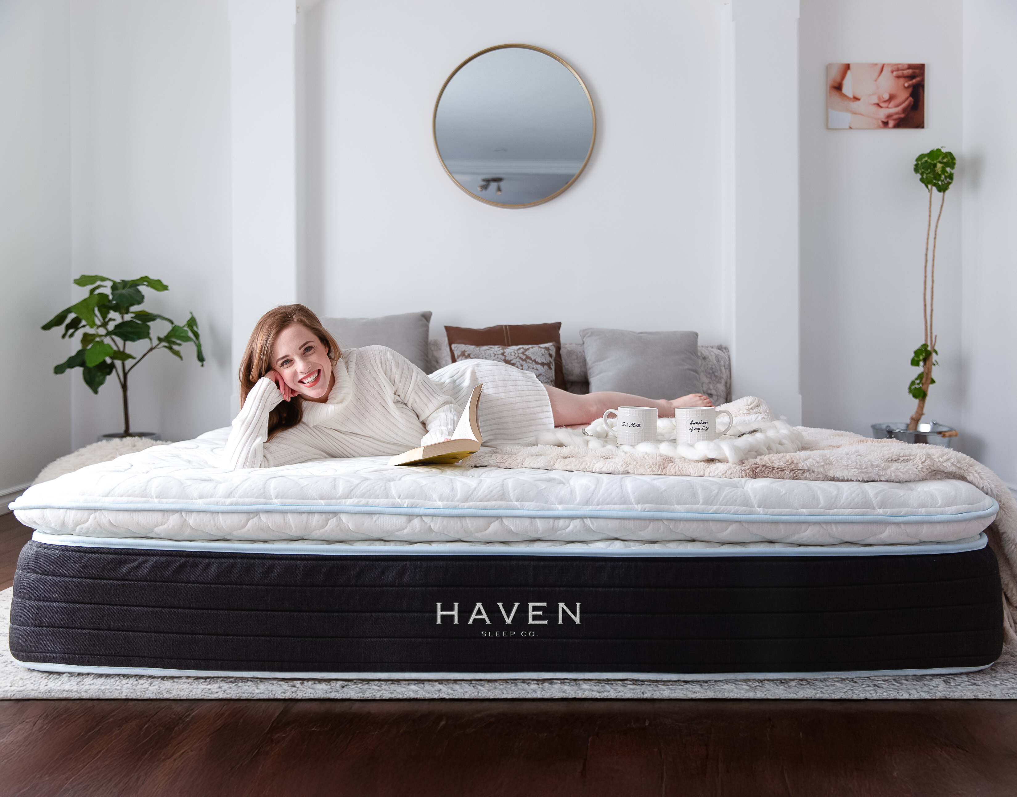 Woman relaxing on a luxurious Haven LUX Pillowtop mattress in a cozy, modern bedroom, highlighting the comfort and quality of 100% Canadian-made mattresses and bedding.