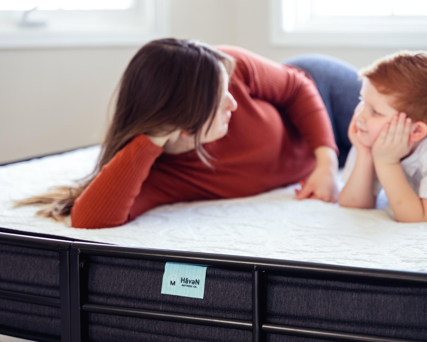 Mother and child relaxing on a Haven mattress, enjoying comfort and support in a bright bedroom.