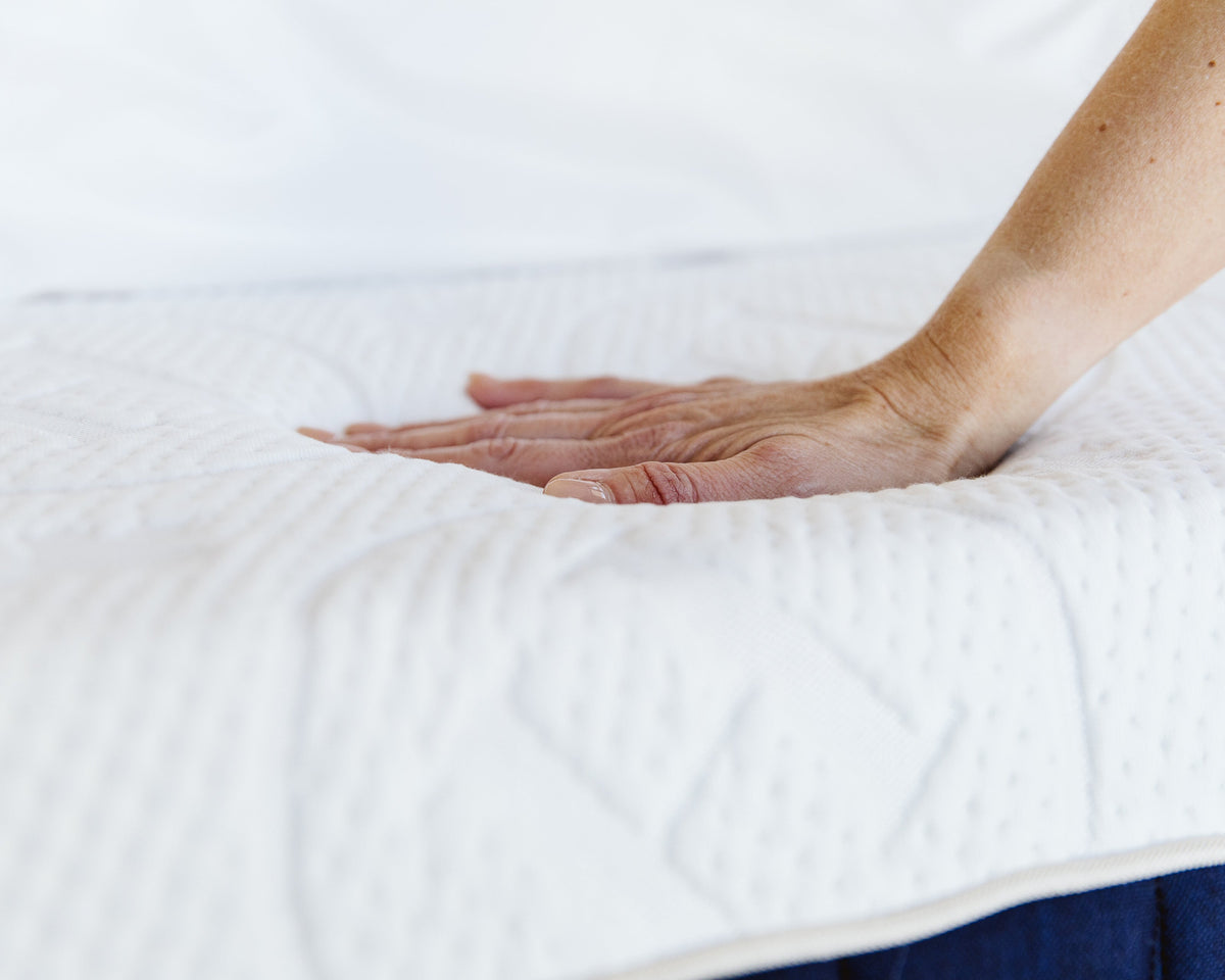 Hand pressing on the top of a Contour mattress