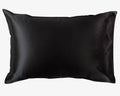 Black satin pillowcase from the Dream Satin Sleep Set, featuring a smooth and glossy finish that is a sustainable and cruelty-free alternative to traditional silk, designed to protect hair and provide a luxurious sleep experience.