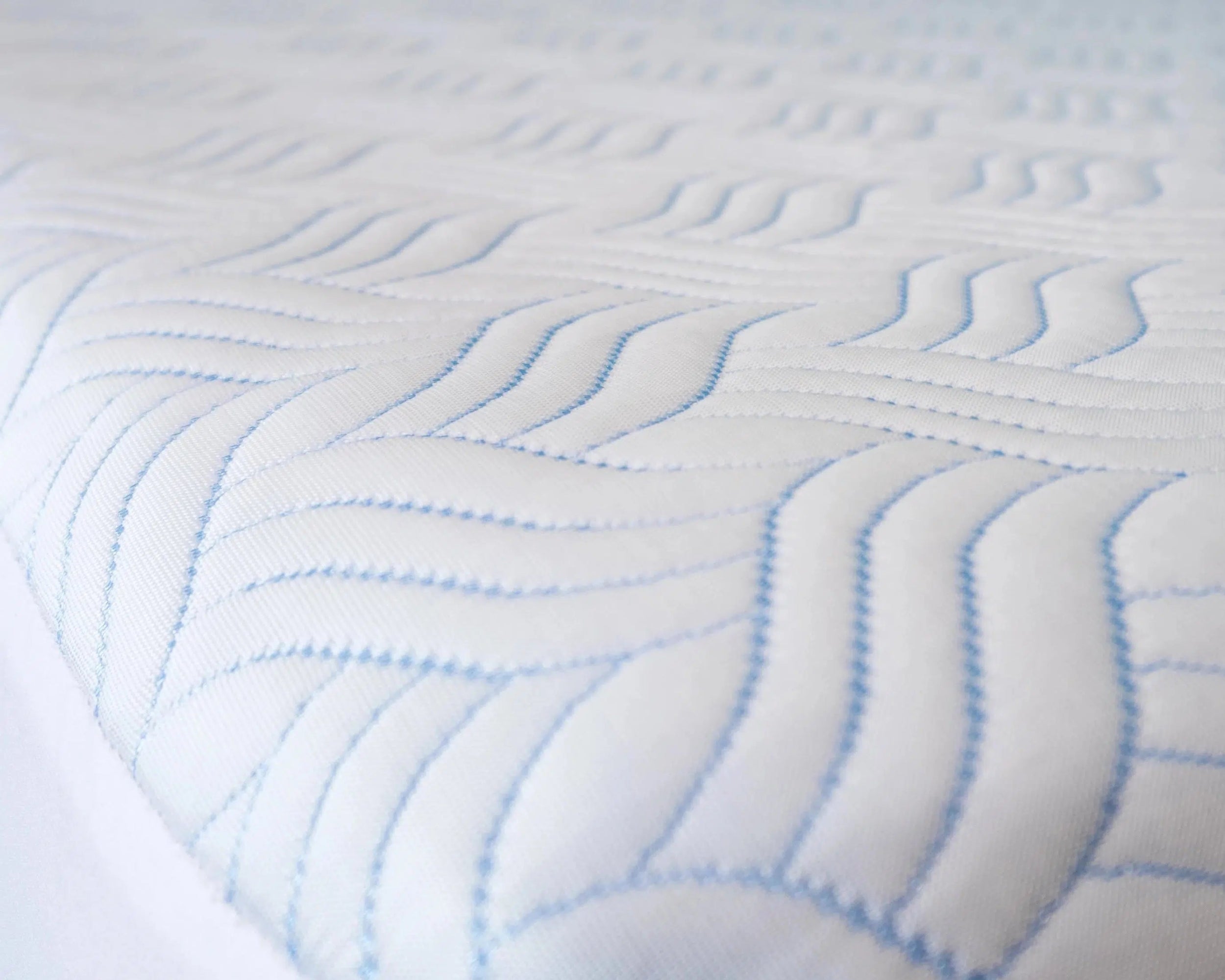 Side View of Haven Cool Ice Mattress Protector on Bed - Breathable, Waterproof Fabric with Wavy Stitching
