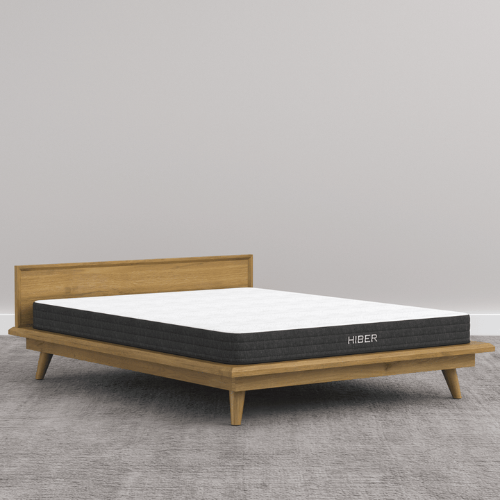 HIBER NaturFoam Mattress placed on a modern wooden bed frame, showcasing its sleek design and comfortable profile, part of the HIBERNate Kids Bundle.