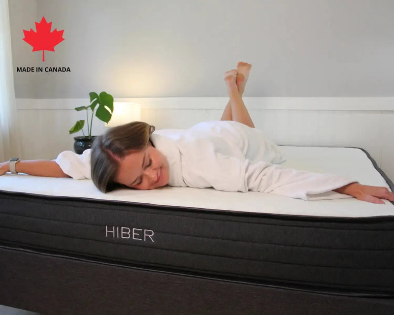 Side view of HIBER8 8-inch mattress with woman in white robe resting comfortably, showcasing Canadian-made comfort.

