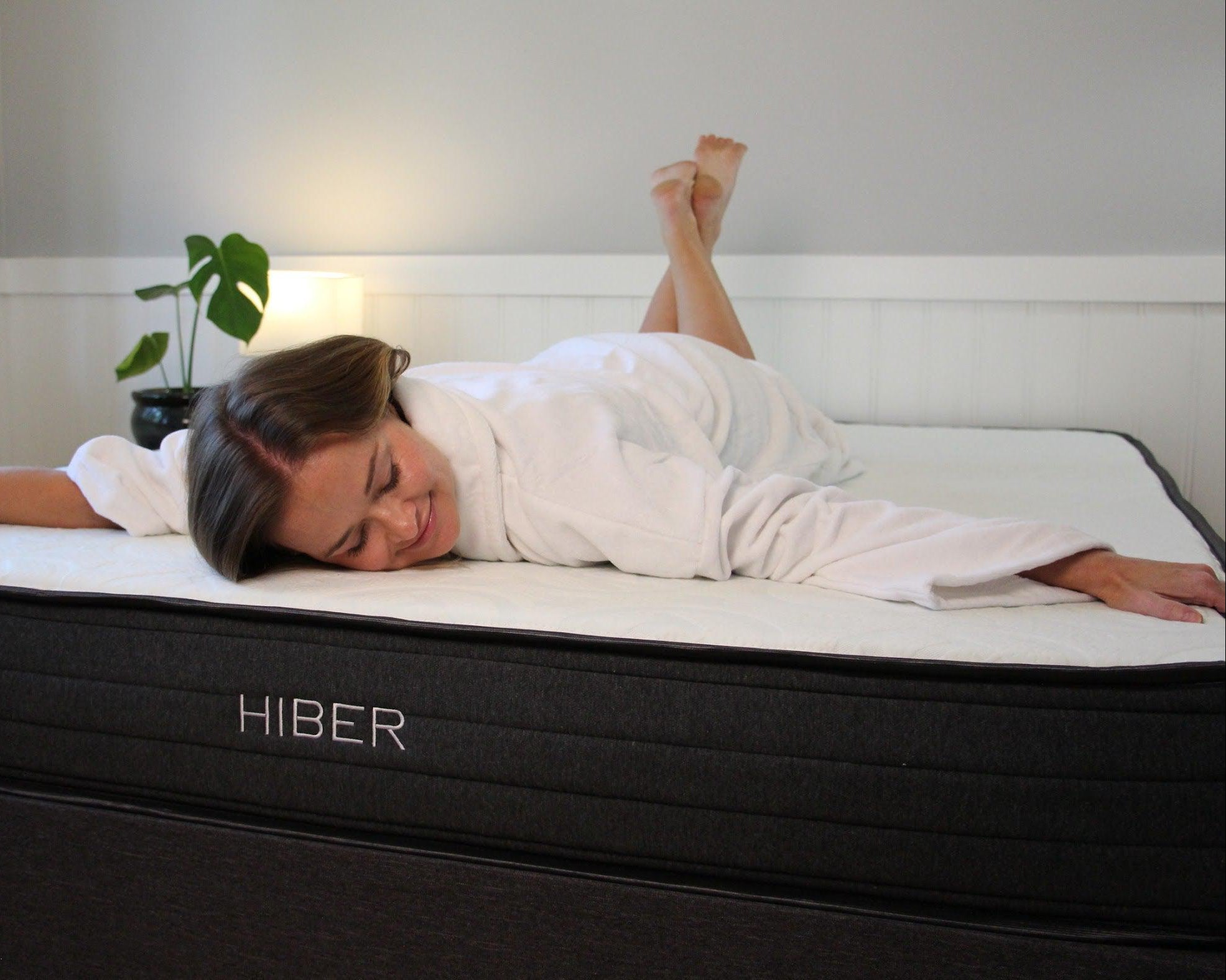 Person in a white robe enjoying the comfort of the HIBER8 RV Mattress, an 8-inch compact mattress made in Canada using NaturFoam technology for optimal comfort, support, and motion isolation, with a cool-to-the-touch Bamboo cover.