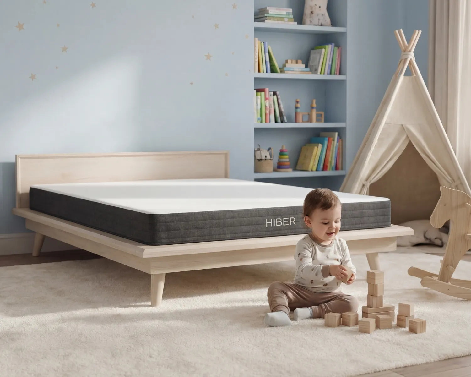 Child playing with wooden blocks near a Hiber mattress in a room with a bookshelf and teepee.