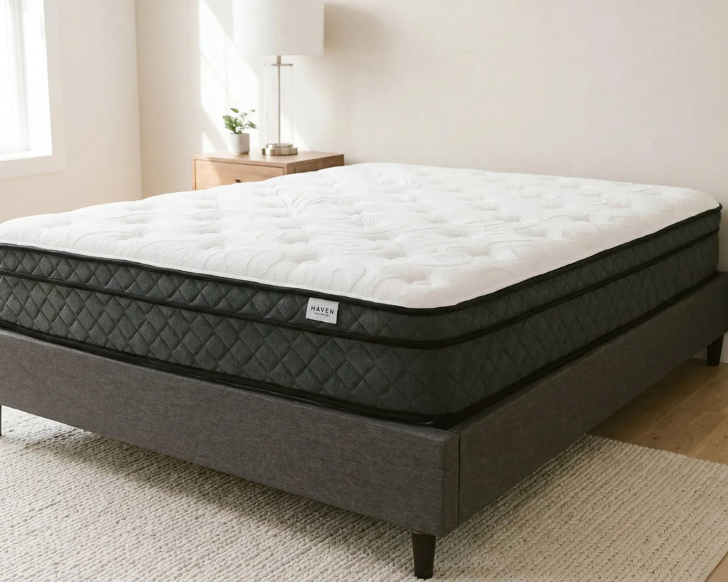 Mattress on a bed frame in a room with light-colored walls and wooden flooring.