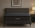 Black Haven mattress on a bed in a room with a lamp and framed art on the wall.
