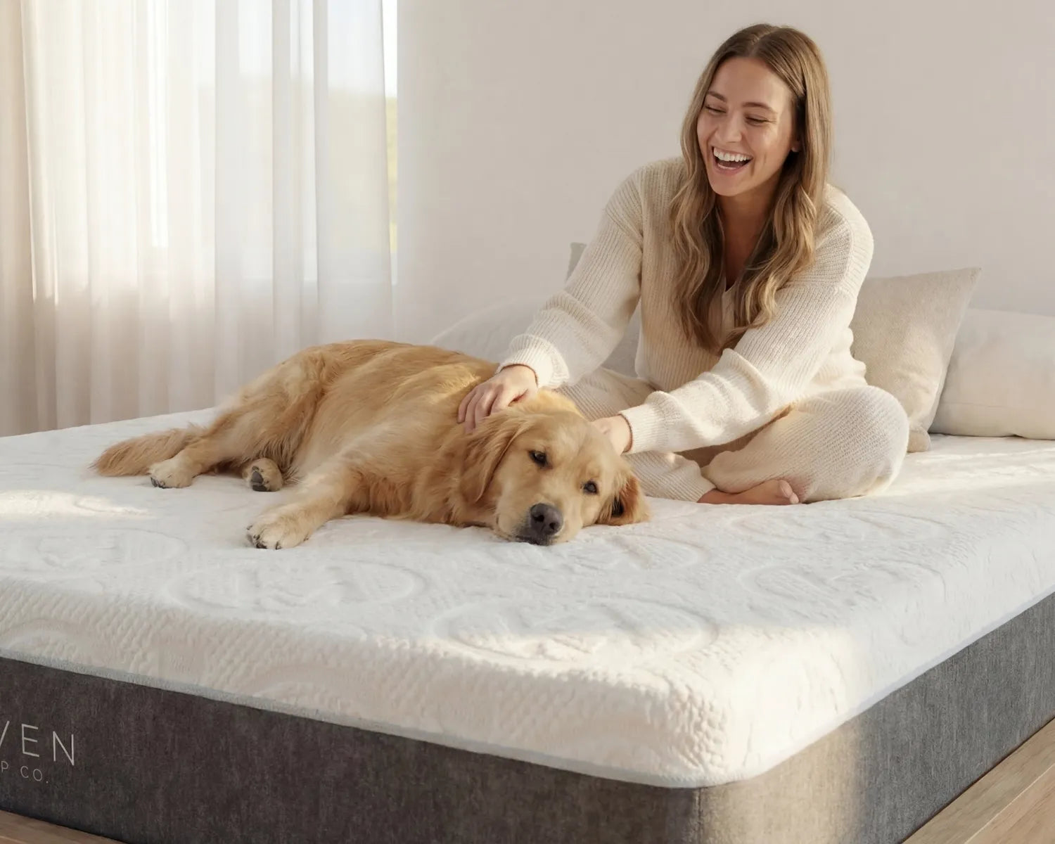 Woman sitting on a bed with a dog, both on a Haven mattress.