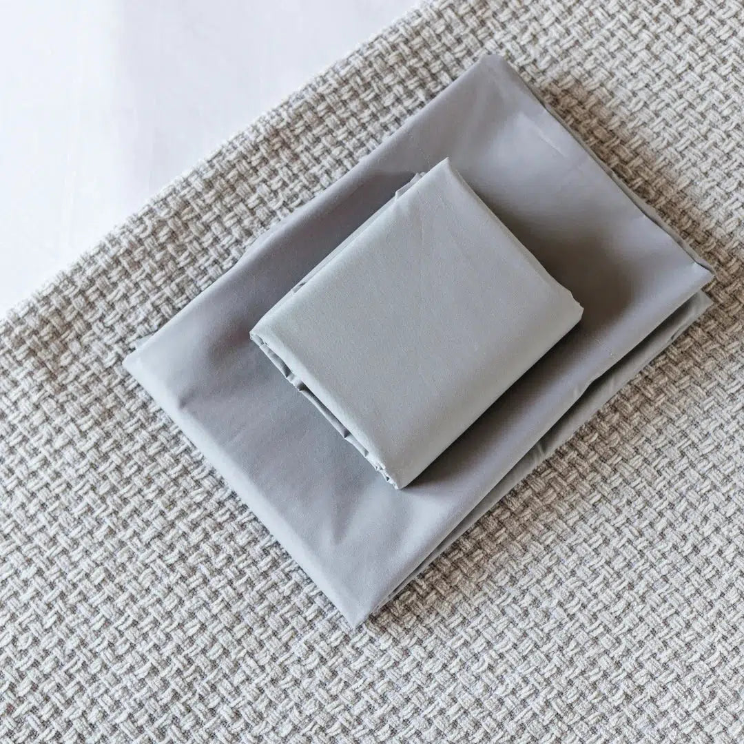 Love of sleep bedface sheets in storm grey on a sand throw