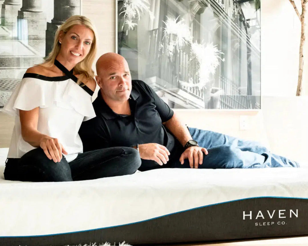 Sarah and Bryan Baeumler relaxing on a Haven LUX Rejuvenate mattress, highlighting the mattress's comfort and luxury in a stylish, modern bedroom setting.