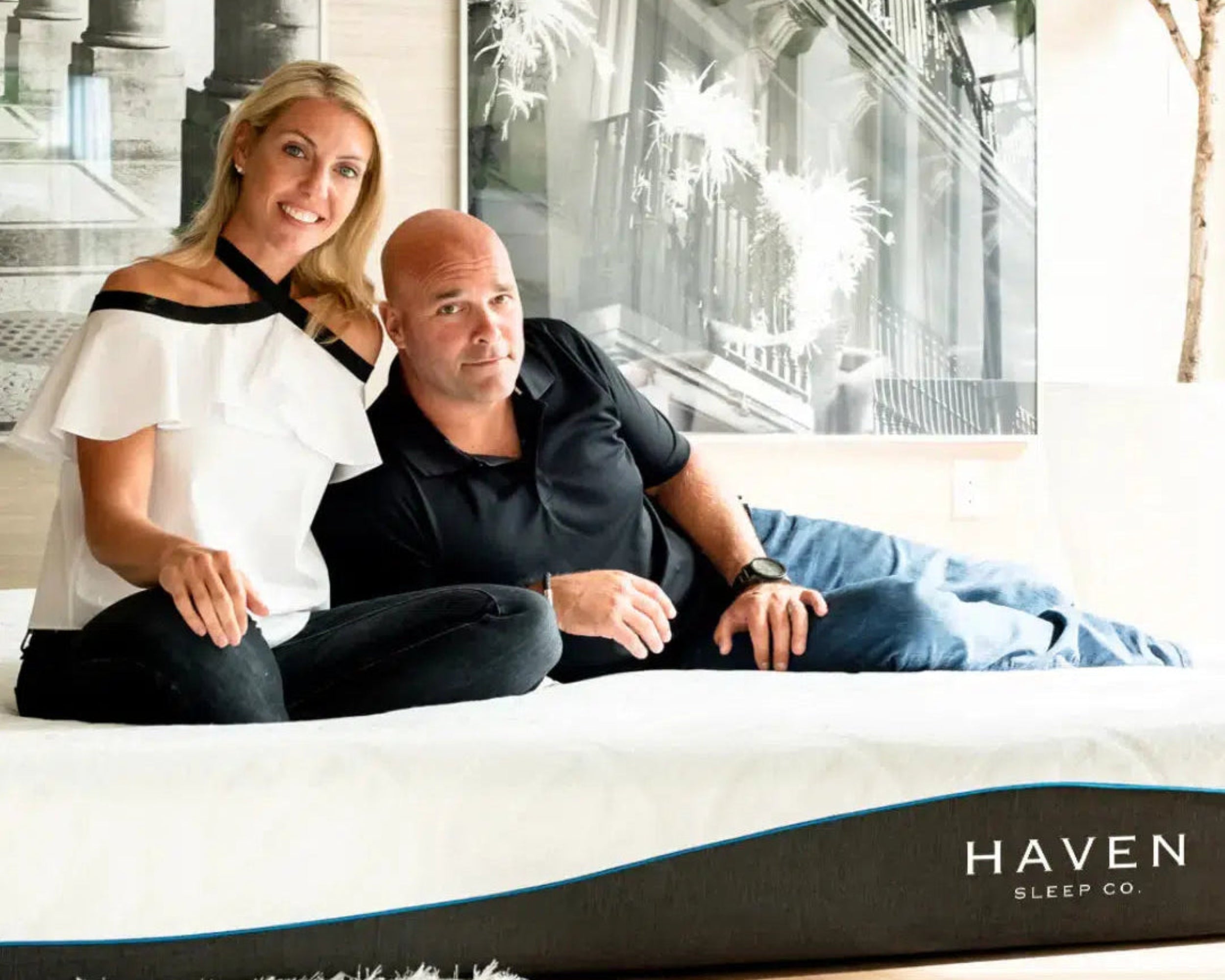 Sarah and Bryan Baeumler relaxing on a Haven LUX Rejuvenate mattress, highlighting the mattress's comfort and luxury in a stylish, modern bedroom setting.