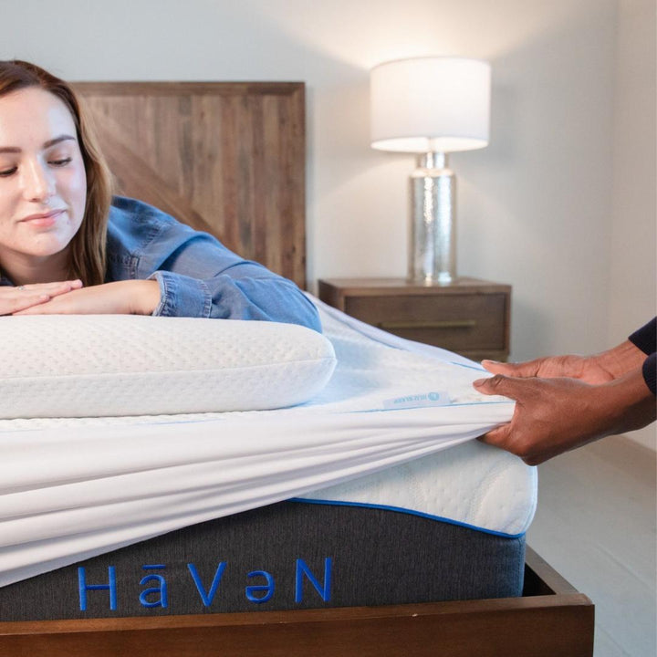 girl laying on mattress with mattress protector pulling over the side of the mattress